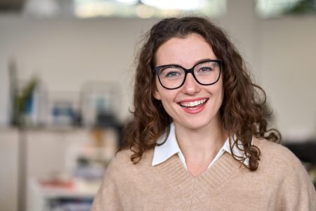 Young happy professional business woman wearing glasses, headshot portrait.